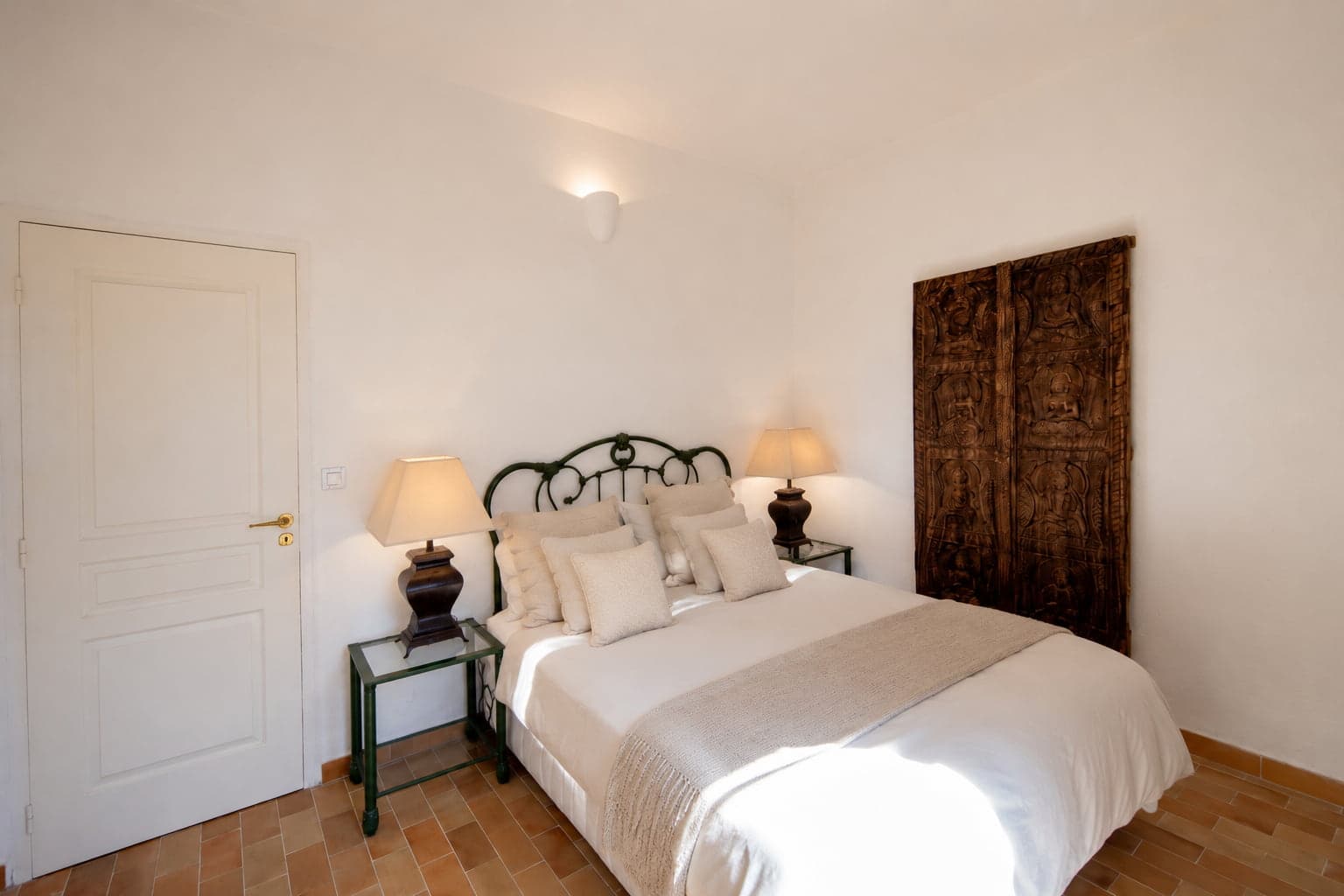 Chambre du Domaine Diva, tête de lit en fer forgé et panneau de bois sculpté