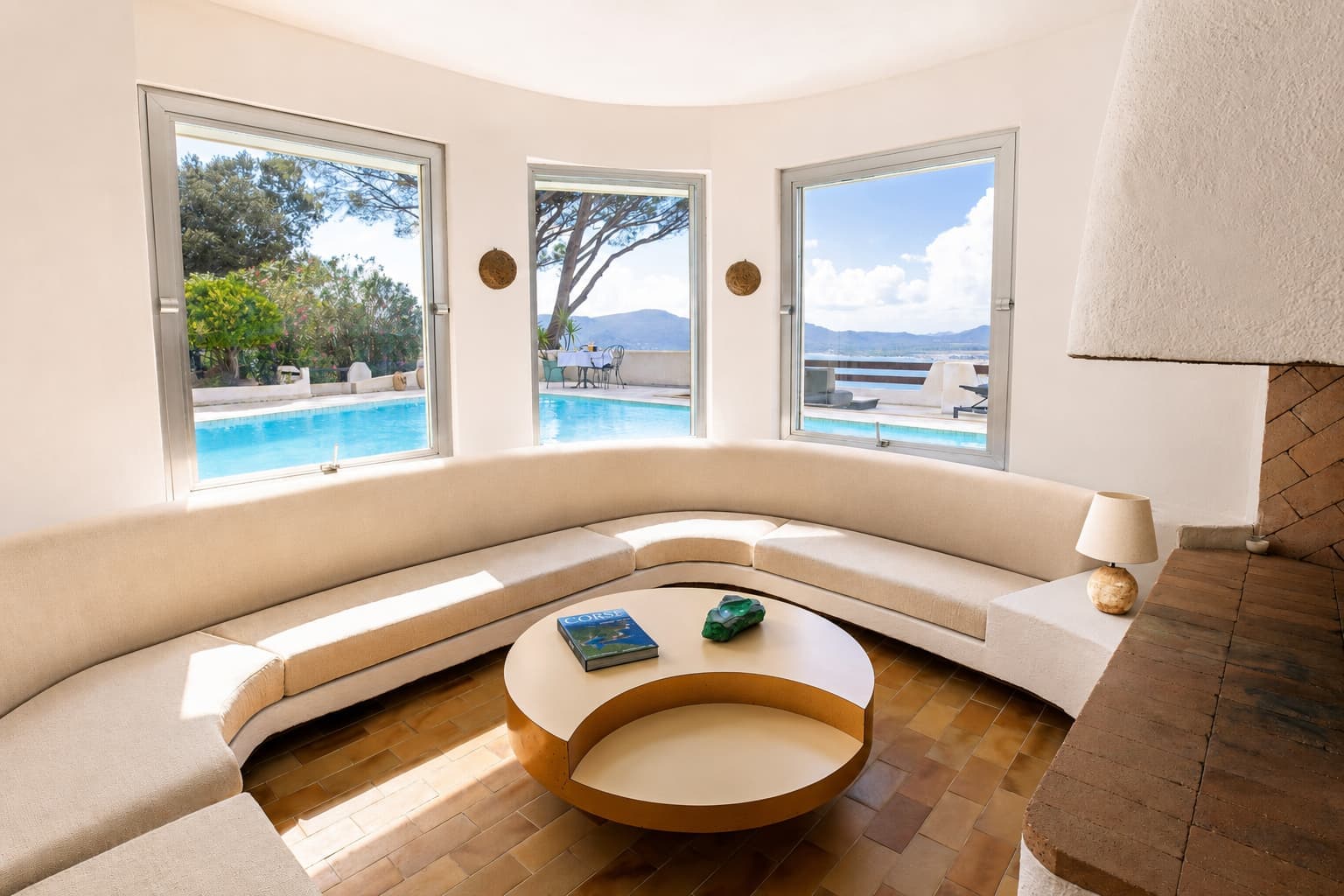 Salon arrondi aux larges baies ouvrant sur la piscine et le golfe de Porto-Vecchio