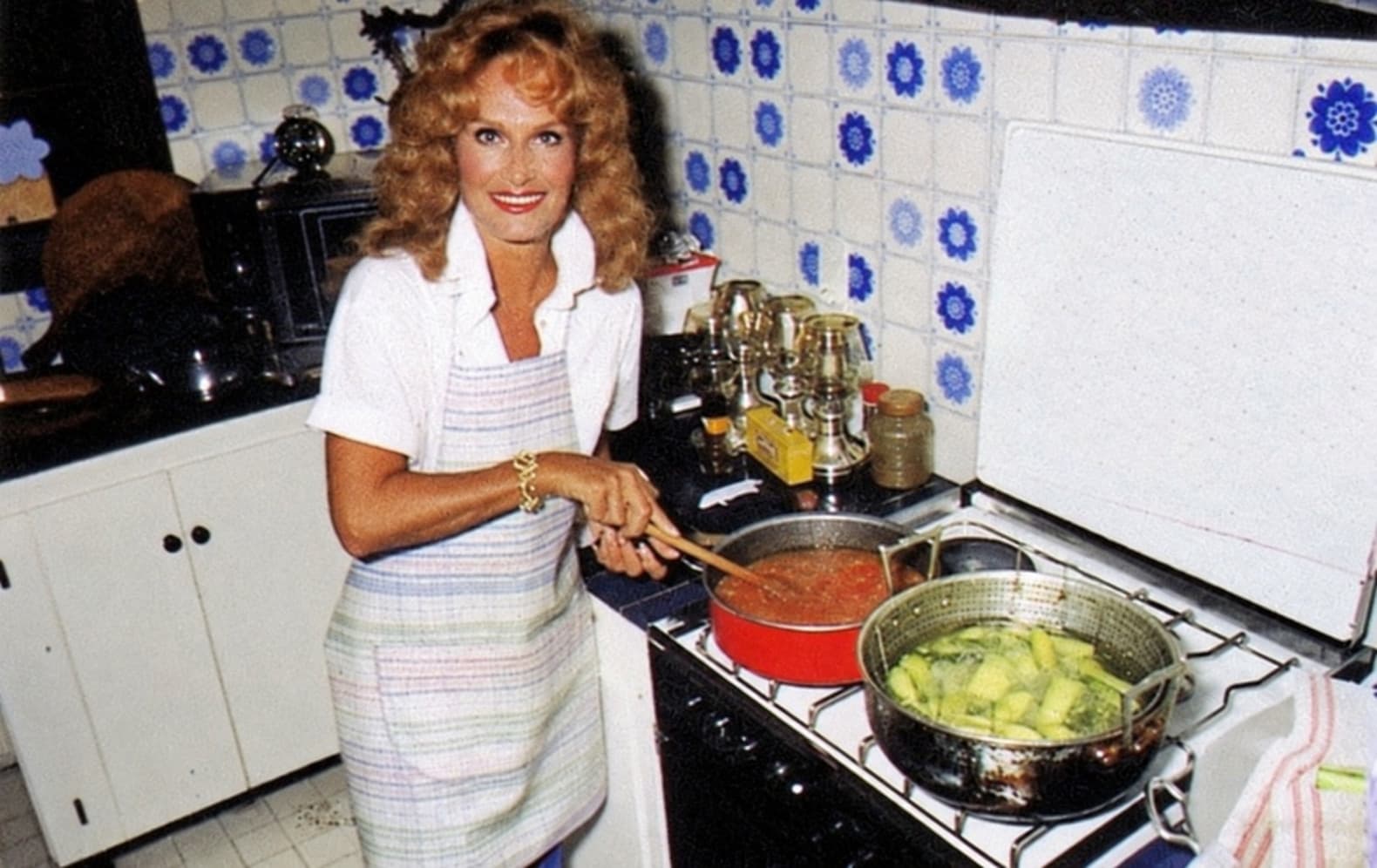 Dalida en la cocina, delante de los azulejos de flores azules