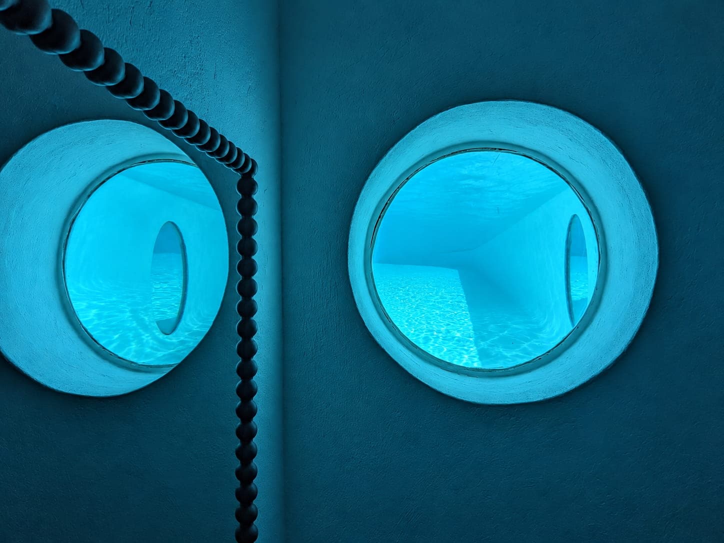 Glazed portholes opening onto the pool, Domaine Diva