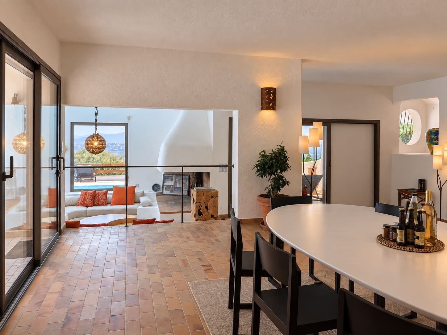 Desde la entrada, la mesa del comedor, la barandilla y la terraza al fondo