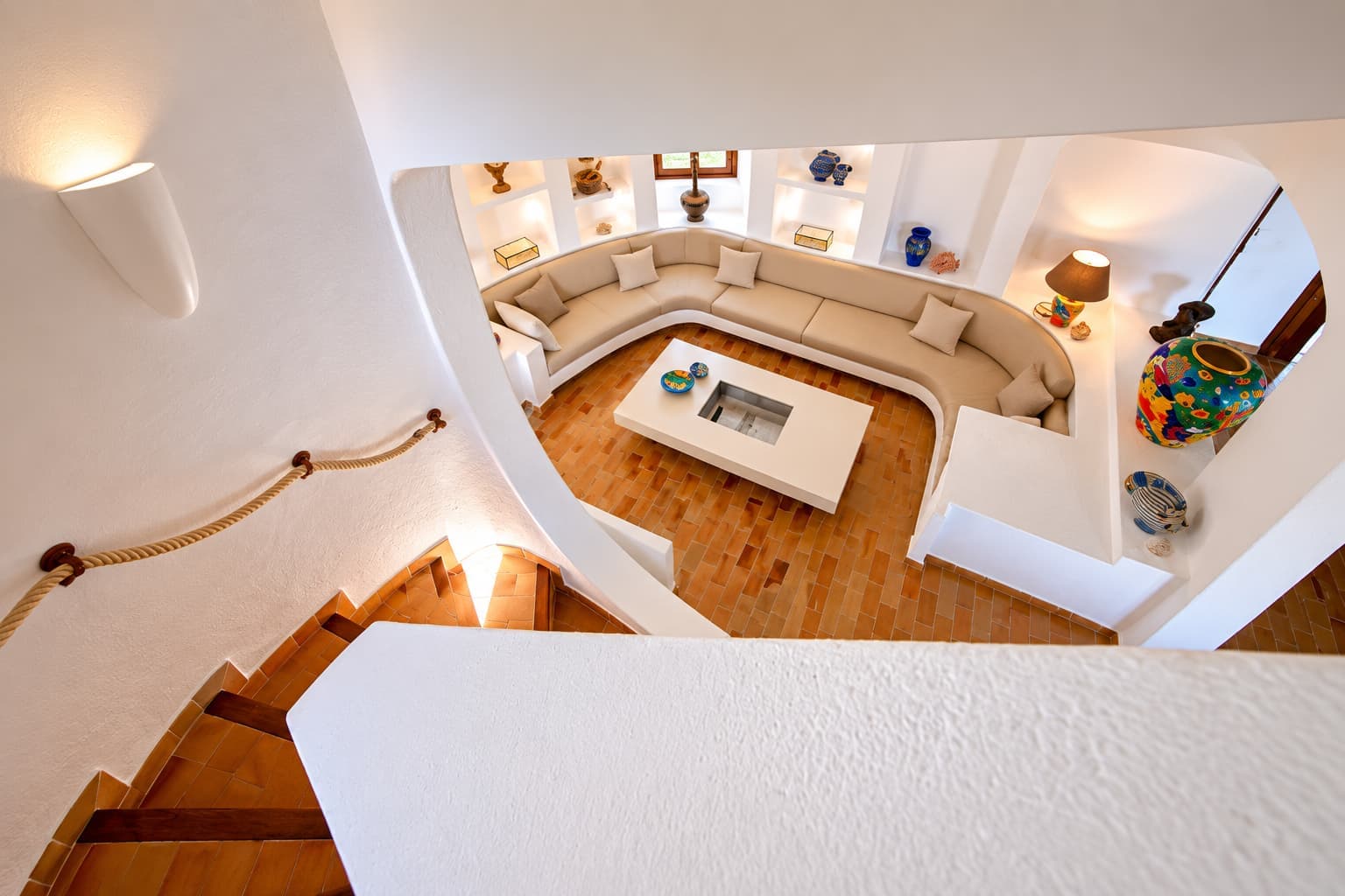 Salon en contrebas du Domaine Diva, banquette courbe et céramiques colorées